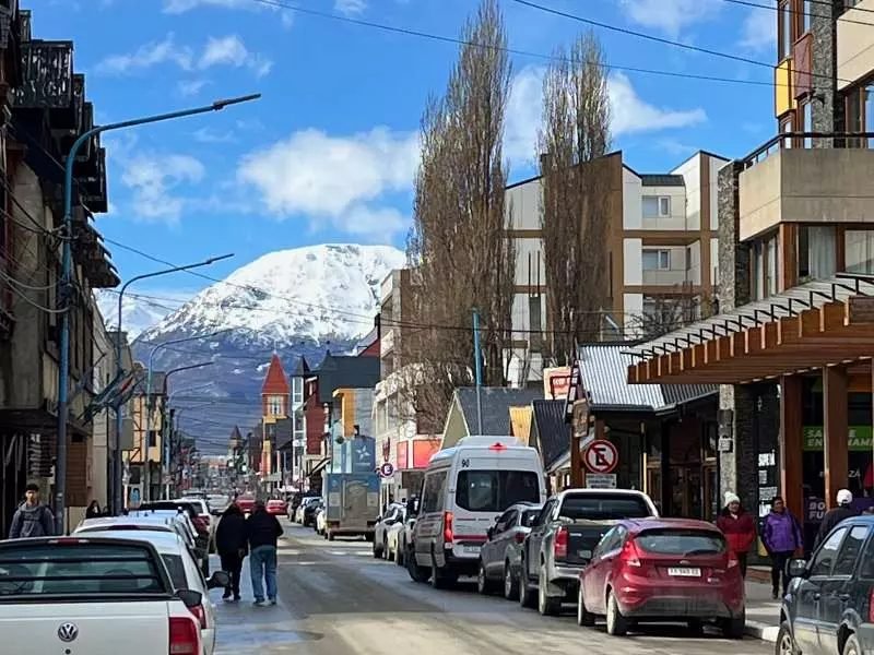 Rua de Ushuaia com montanhas nevadas ao fundo